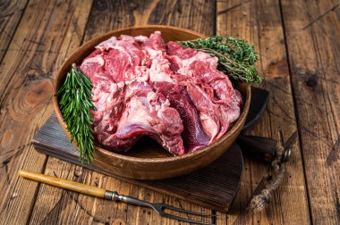 Kemiksiz çiğ koyun eti, ahşap tabakta, otlu omuz eti. Ahşap arka plan. Üst görünüm