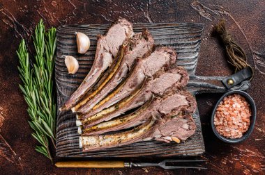 Ahşap tahtada ızgara kuzu pirzola bifteği. Karanlık arka plan. Üst görünüm