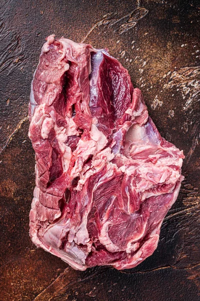 Carne cruda di agnello disossata sul tavolo del macellaio. Sfondo scuro. Vista dall'alto — Foto Stock
