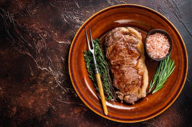 Kızarmış New York bifteği ya da kırsal bir tabakta striploin. Karanlık arka plan. Üst Manzara. Boşluğu kopyala