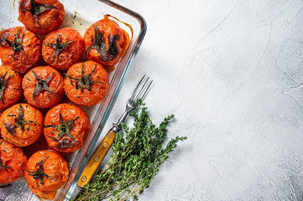 Tomates cherry al horno con aceite de oliva y tomillo en bandeja para hornear. Fondo blanco. Vista superior. Copiar espacio — Foto de Stock