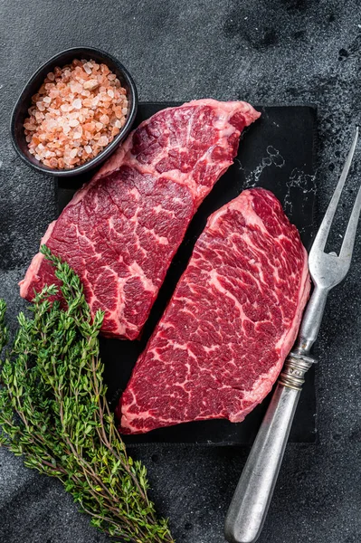 新鲜生鲜的丹佛牛排牛肉配香草.黑色背景。顶部视图 — 图库照片