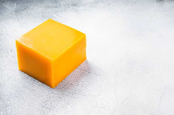 Bloque de queso Cheddar en una mesa de cocina. Fondo blanco. Vista superior. Copiar espacio — Foto de Stock