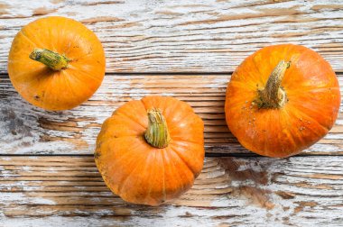 Çiğ turuncu balkabağı. Beyaz ahşap arka plan. Üst görünüm