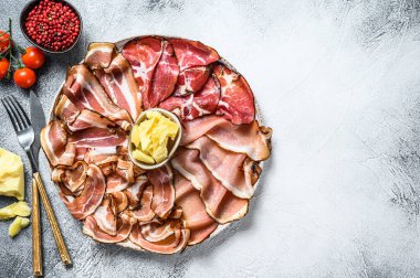 Et antipasto tabağı, pancetta, salam, dilimlenmiş jambon, sosis, jambon, jambon. Gri arka plan. Üst Manzara. Boşluğu kopyala