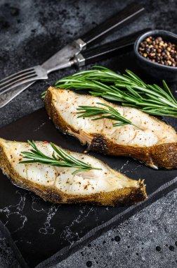 Biberiyeli balık bifteği. Siyah arka plan. Üst görünüm