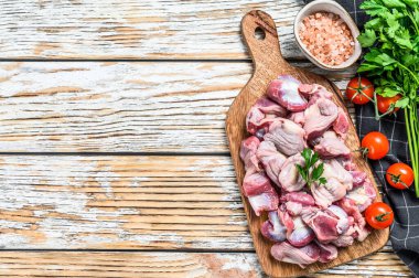 Çiğ çiğ tavuk taşakları, kesme tahtasındaki mide. Ahşap arka plan. Üst Manzara. Boşluğu kopyala