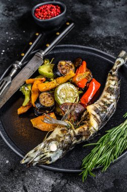 Izgara sebzeli buzlu balık. Siyah arka plan. Üst görünüm