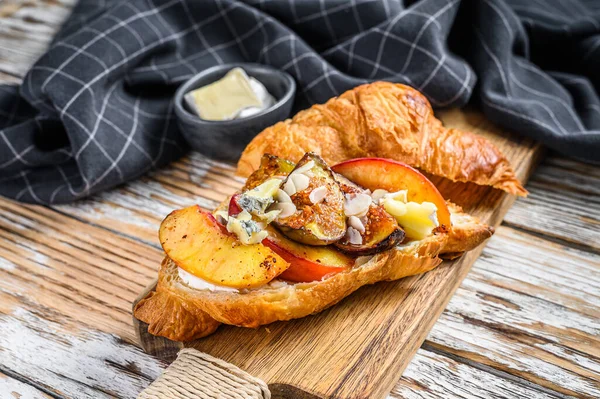 Sanduíche de croissant fresco com queijo brie, pêssego e figos. Delicioso pequeno-almoço. Fundo branco. Vista superior — Fotografia de Stock