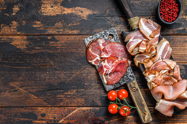 Meat antipasto board, pancetta, salami, sliced ham, sausage, prosciutto, bacon with grape and parmesan cheese. Wooden background. Top view. Copy space