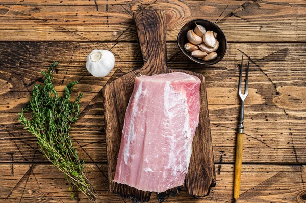 Lomo de cerdo crudo con especias sobre tabla de madera. fondo de madera. Vista superior — Foto de Stock
