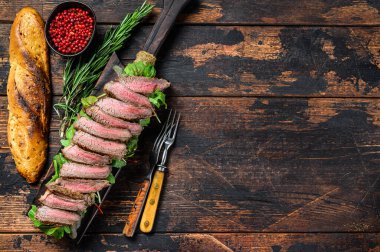 Biftekli baget sandviç ve yanında roka. Koyu ahşap arka plan. Üst Manzara. Boşluğu kopyala