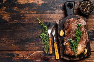 Kesme tahtasının üzerinde ızgara Chuck 'ın gözleme bifteği. Koyu ahşap arka plan. Üst Manzara. Boşluğu kopyala