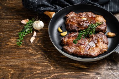 Tavada kızarmış pirzola bifteği. Koyu ahşap arka plan. Üst Manzara. Boşluğu kopyala