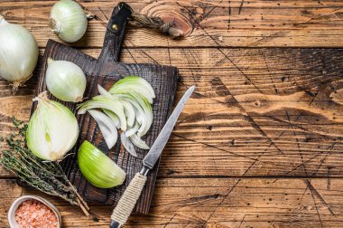 Tahta kesme tahtasında dilimlenmiş çiğ beyaz soğan. Ahşap arka plan. Üst Manzara. Boşluğu kopyala