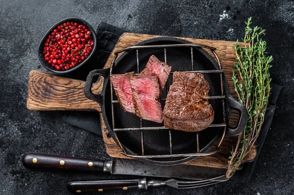 Grillad filé mignon biff på en grill. Svart bakgrund. Ovanifrån — Stockfoto