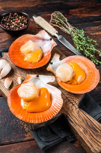 Fresh raw Scallops in shells on a rustic wooden board with thyme. Dark wooden background. Top view — Stock Photo, Image