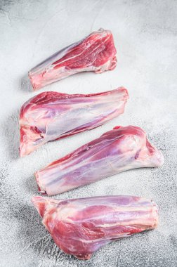 Taş masada çiğ kuzu incik eti. Beyaz arka plan. Üst görünüm