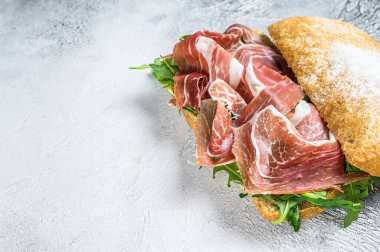 Ciabatta ekmeğinde roka soslu jambonlu jambonlu jambonlu jambonlu jambonlu jambonlu sandviç. Beyaz arka plan. Üst Manzara. Boşluğu kopyala