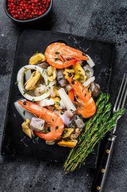 Karides, karides, midye, mürekkep balığı ve ahtapotla taze deniz ürünleri karışımı. Siyah arka plan. Üst görünüm