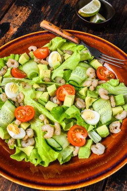 Deniz ürünleri avokadosu, karides, karides salatası. Koyu ahşap arka plan. en üstteki görünüm