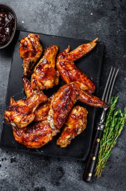 Sucuk soslu ızgara tavuk kanadı. Siyah arka plan. Üst görünüm