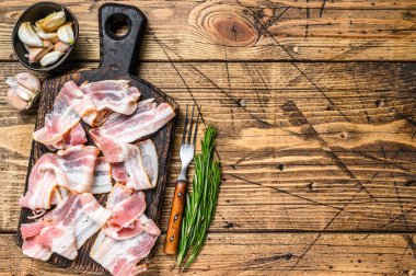 Ahşap kesme tahtasının üzerinde domuz pastırması. Ahşap arka plan. Üst Manzara. Boşluğu kopyala