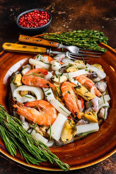 Karides, karides, midye, mürekkep balığı ve ahtapotlu deniz ürünleri kokteyli. Koyu ahşap arka plan. Üst görünüm