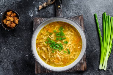 Masada erişteli taze ev yapımı tavuk çorbası. Siyah arka plan. Üst görünüm
