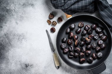 Tahta bir masada tavada kestane kızart. Beyaz arka plan. Üst Manzara. Boşluğu kopyala