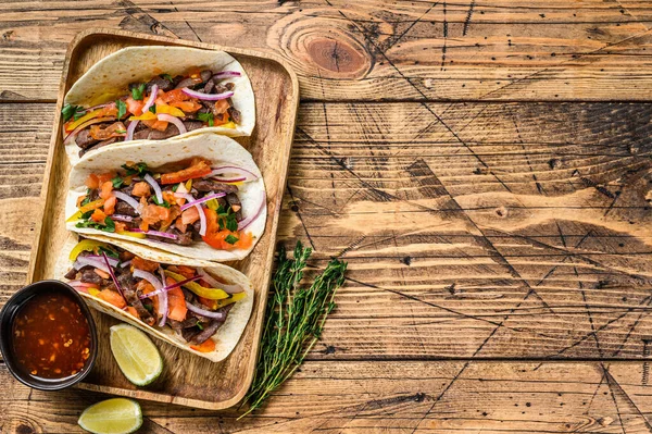 Tacos mit Rindfleisch, Zwiebeln, Tomaten, Paprika und Salsa. Mexikanisches Essen. Holzuntergrund. Ansicht von oben. Kopierraum — Stockfoto