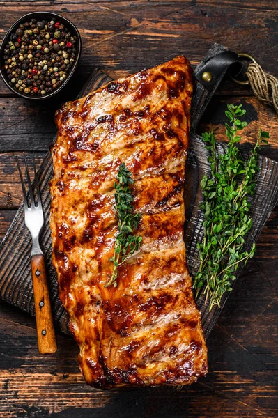 Kesme tahtasında ızgara domuz pirzolası. Ahşap arka plan. Üst görünüm