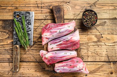 Taze çiğ keçi eti, bitkisel ve biberli. Ahşap arka plan. Üst görünüm