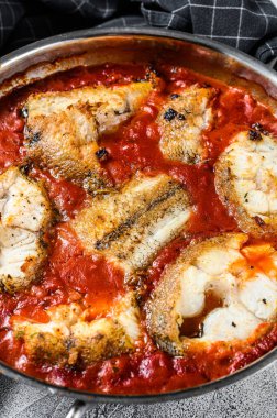 Tavada domatesli haşlanmış beyaz balık. Beyaz tahta arka plan. Üst görünüm