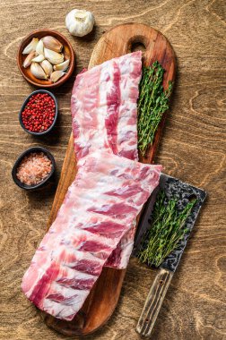 Çiğ domuz pirzolası, baharat, sarımsak ve kekik. Ahşap arka plan. Üst görünüm