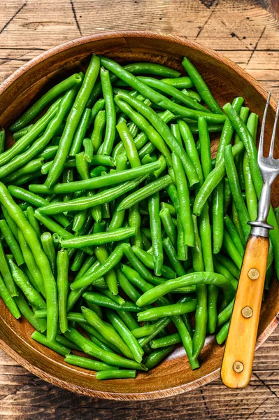 Cooked green beans in a wooden plate. wooden background. top view — Stock Photo, Image