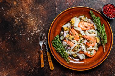 Çiğ deniz ürünleri kokteyli karides, karides, midye, mürekkep balığı ve ahtapotla karıştırılmış. Koyu ahşap arka plan. Üst Manzara. Boşluğu kopyala