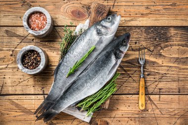 Tahta kesme tahtasının üzerinde biberiyeli taze deniz ürünü. Ahşap arka plan. Üst görünüm