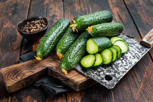 Sliced Green Cucumbers on a wooden cutting board. Dark Wooden background. Top view — Stock Photo, Image