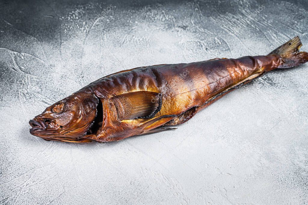 Hot smoked whole fish on kitchen table. White background. Top view