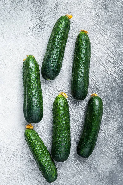 Pepinos verdes orgânicos em uma mesa de cozinha. Fundo branco. Vista superior — Fotografia de Stock