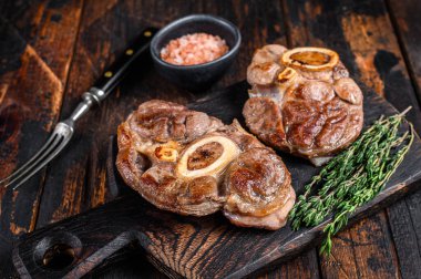Osso Buco bifteği, İtalyan ossobuco bifteği. Koyu ahşap arka plan. Üst görünüm