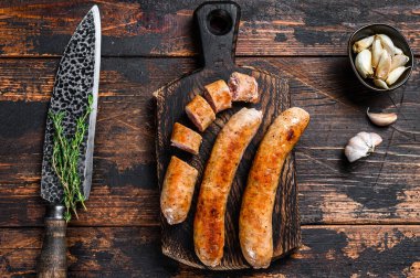 Kızarmış ve dilimlenmiş domuz sosisi ve otlar. Üst Manzara. Koyu tahta arkaplan