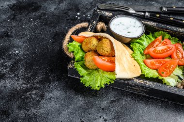 Sebzeli falafel, pide sosu, vejetaryen kebap sandviçi. Siyah arka plan. Üst Manzara. Boşluğu kopyala