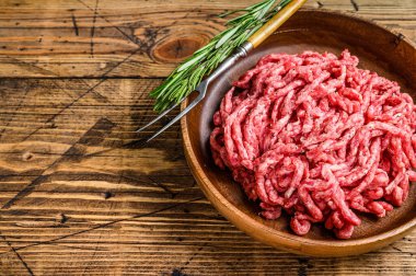 Çiğ kıymalı kuzu eti, tabakta otlu kuzu eti. Ahşap arka plan. Üst Manzara. Boşluğu kopyala