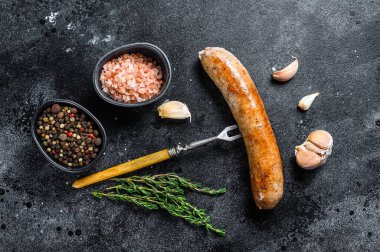 Et çatalında baharat ve otlarla kızartılmış sosis ızgarası. Üst Manzara. Siyah arkaplan