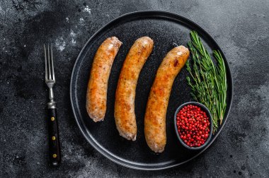 Tabakta baharat ve otlarla kızartılmış sosisler. Üst Manzara. Siyah arkaplan