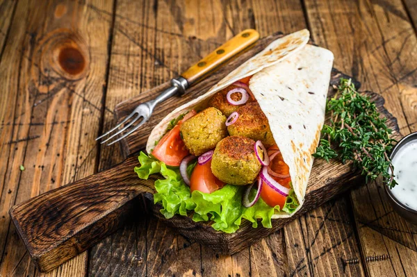 Vegetarische Tortilla wrap met falafel en verse salade, veganistische taco 's. houten achtergrond. Bovenaanzicht — Stockfoto