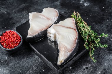 Tahtada çiğ köpekbalığı bifteği. Siyah arka plan. Üst görünüm