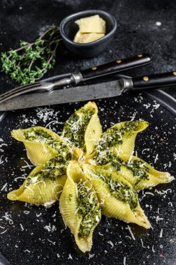 Konkiloni İtalyan Jumbo kabuklu Konchiglioni makarnası sığır eti ve ıspanakla dolu bir tabak. Siyah arka plan. Üst görünüm